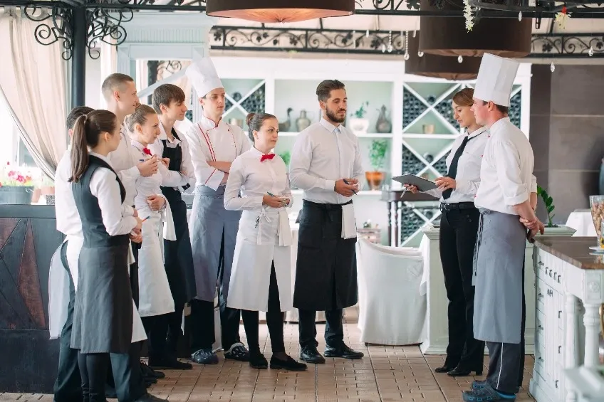 Food Allergen Control : The Complete Guide for UK Manufacturing 5 Restaurant staff and chefs gathered for a food allergen safety training session in a bright dining area.