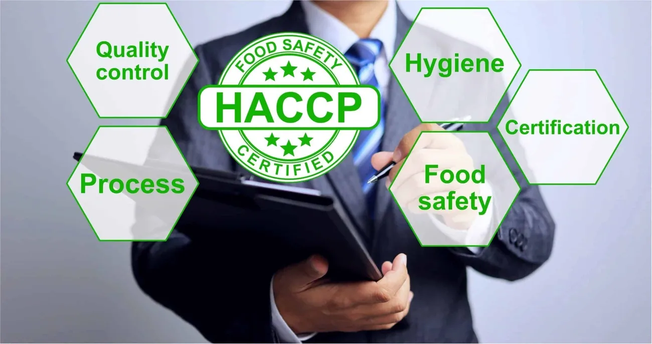 Businessman holding clipboard with HACCP food safety certification and related terms like hygiene and quality control.