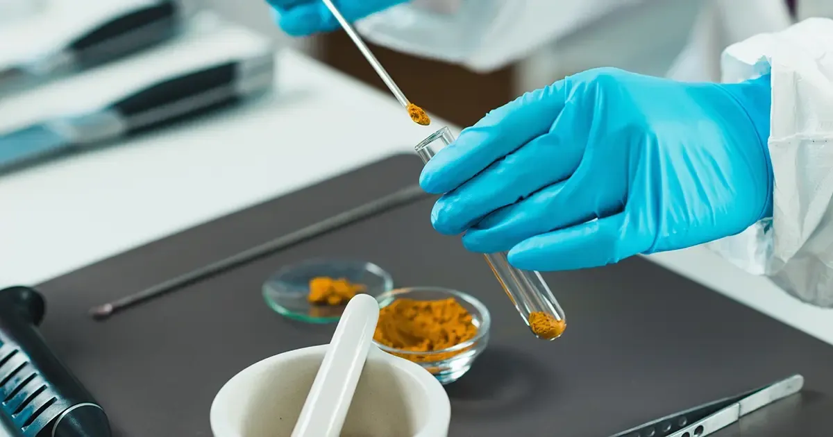 ELISA Allergen Testing Verification: Laboratory Methods and Detection Capabilities 5 Gloved hand placing yellow powder into a test tube for allergen testing in a food lab setting.